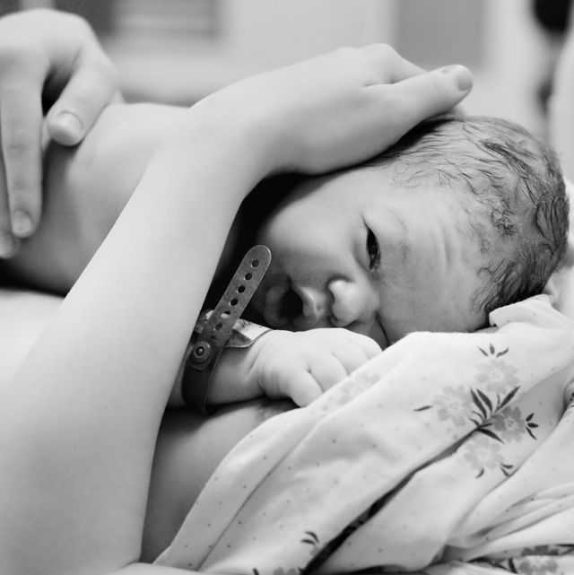 Neugeborenes Baby liegt nach der Geburt auf der Brust der Mutter